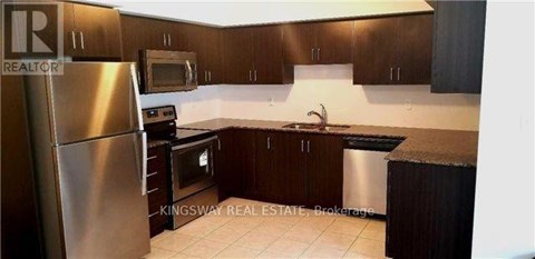 A kitchen with a stainless steel refrigerator, microwave, oven, and sink.