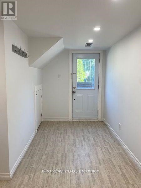 A hallway with a white door and a small window.