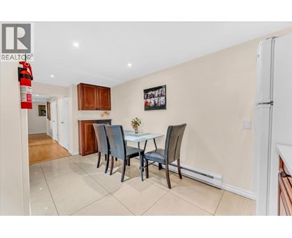 A dining room with a table and chairs.