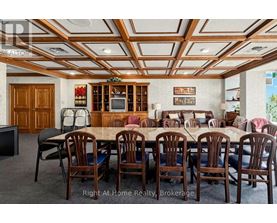 A dining room with a large table and chairs.