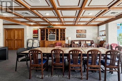 A dining room with a large table and chairs.