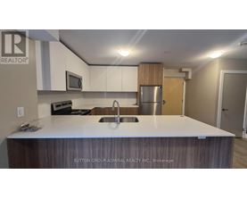 A kitchen with a sink and a refrigerator.