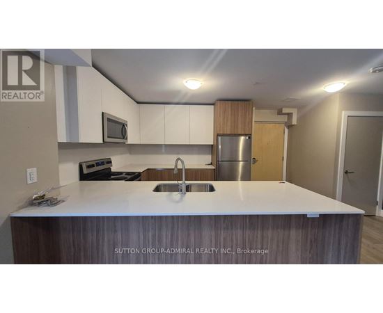 A kitchen with a sink and a refrigerator.
