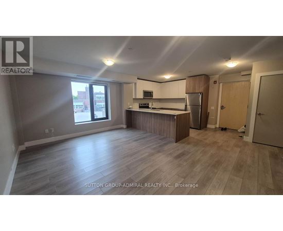 A spacious kitchen with a refrigerator, microwave, and oven.