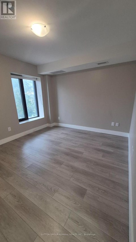 A room with wooden flooring and a window.