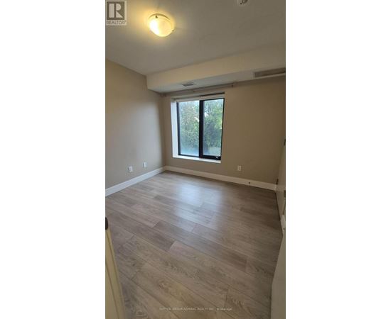 A room with a window and wooden flooring.