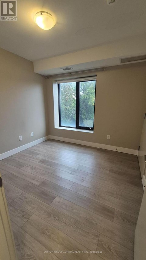 A room with a window and wooden flooring.