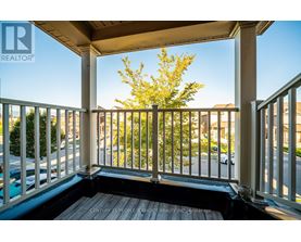 A balcony with a view of a street and houses.