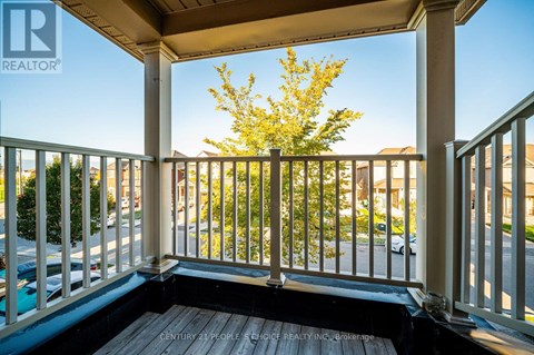 A balcony with a view of a street and houses.