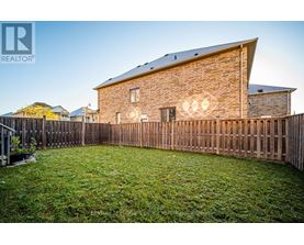 A house with a wooden fence and a green lawn in front.
