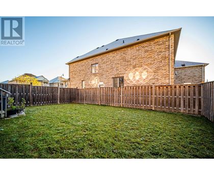 A house with a wooden fence and a green lawn in front.