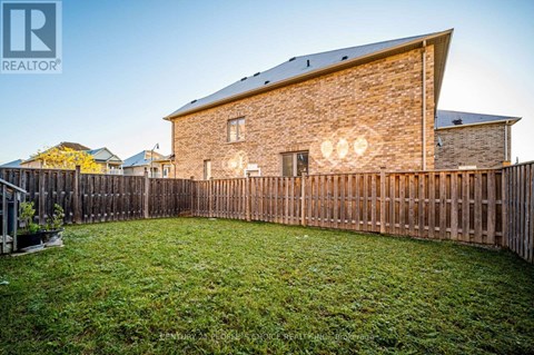 A house with a wooden fence and a green lawn in front.