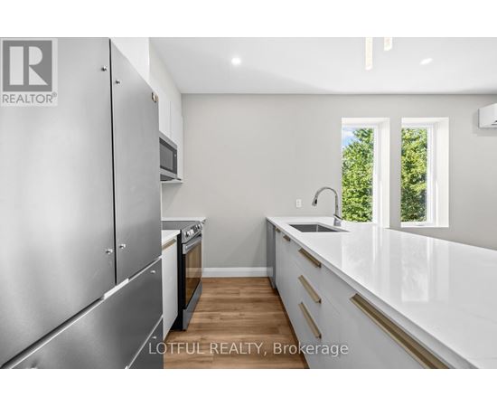 A modern kitchen with stainless steel appliances and white countertops.
