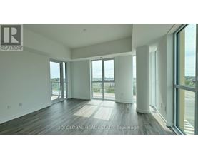 A spacious room with a view of the outdoors through large windows.