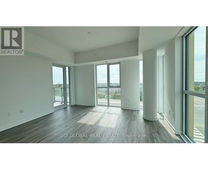 A spacious room with a view of the outdoors through large windows.
