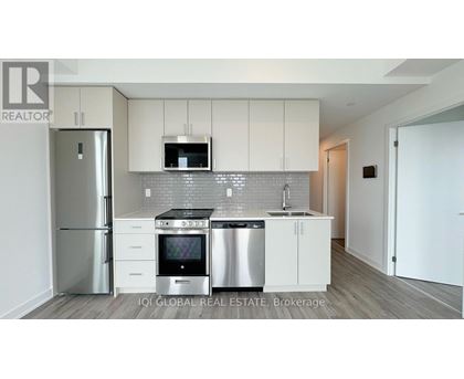 A modern kitchen with white cabinets and stainless steel appliances.