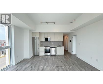 A modern kitchen with white cabinets and stainless steel appliances.