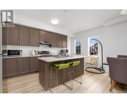 A kitchen with brown cabinets and a white island with green stools.