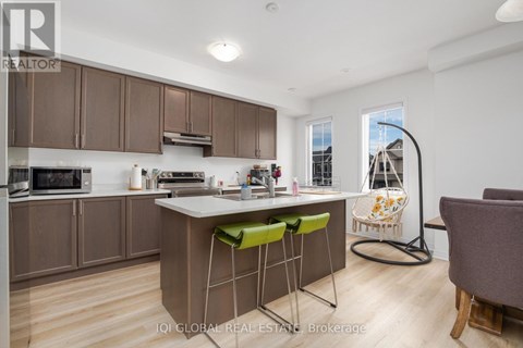 A kitchen with brown cabinets and a white island with green stools.