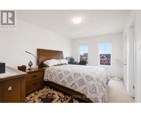 A bedroom with a bed, nightstand, and window.
