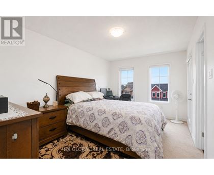 A bedroom with a bed, nightstand, and window.