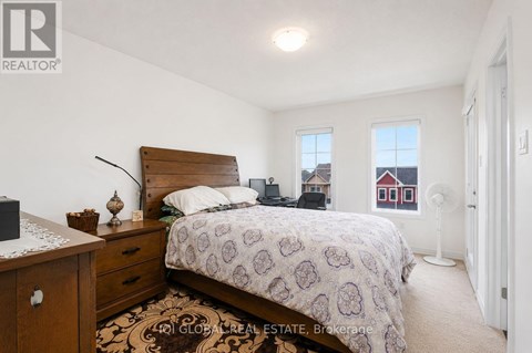 A bedroom with a bed, nightstand, and window.