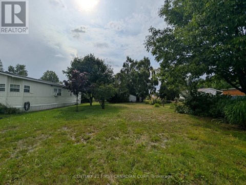 A grassy yard with a white building in the background.