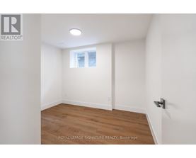 A white room with a wooden floor and a window.