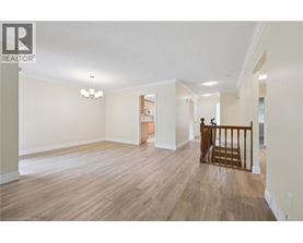 A spacious living room with wood flooring and a chandelier.