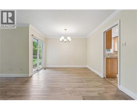 A spacious room with wood flooring and a chandelier.
