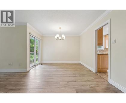 A spacious room with wood flooring and a chandelier.