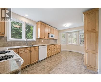 A kitchen with wooden cabinets and a tiled floor.