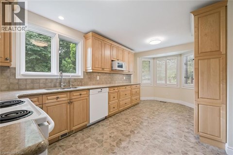 A kitchen with wooden cabinets and a tiled floor.