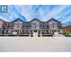 A large apartment complex with multiple buildings and parking spaces in front.