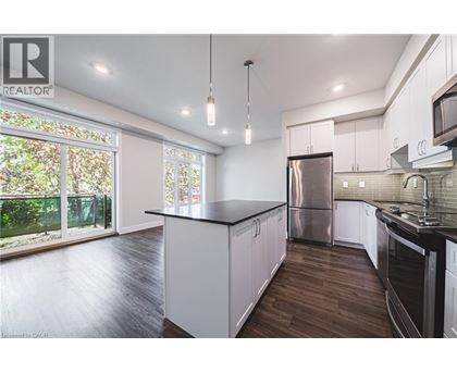 A modern kitchen with white cabinets and a black countertop.