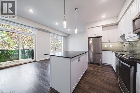 A modern kitchen with white cabinets and a black countertop.