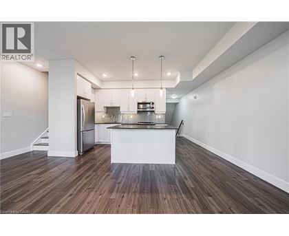 A modern kitchen with wooden floors and white walls.