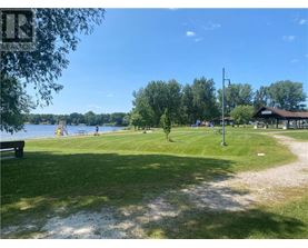A park with a playground and a body of water.