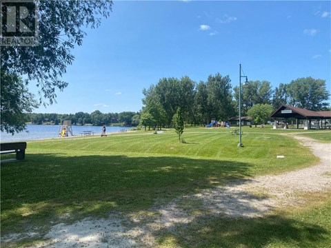 A park with a playground and a body of water.
