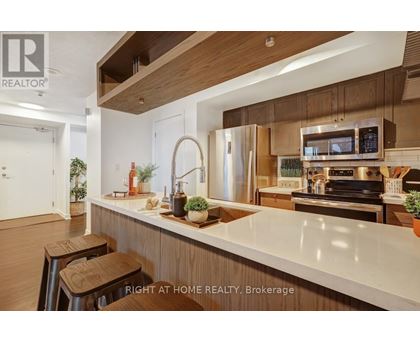 A modern kitchen with wooden cabinets and stainless steel appliances.