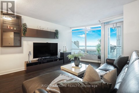 A living room with a leather couch and a flat screen TV.