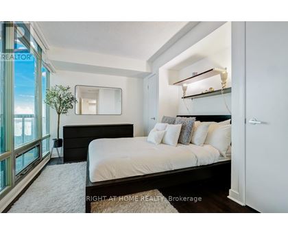 A bedroom with a large bed and a mirror on the wall.