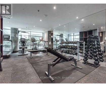 A gym with a variety of equipment including treadmills, weights, and exercise machines.