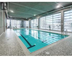 A large indoor swimming pool with a tiled floor and walls.