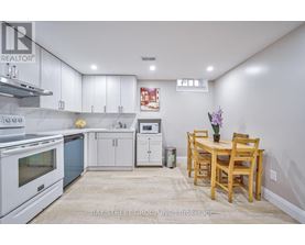 A kitchen with white cabinets and a wooden table.