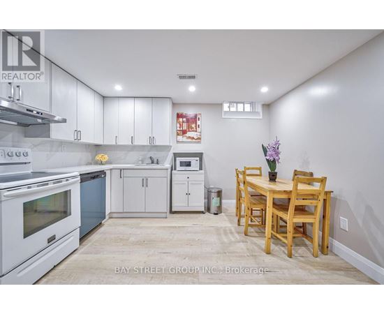 A kitchen with white cabinets and a wooden table.