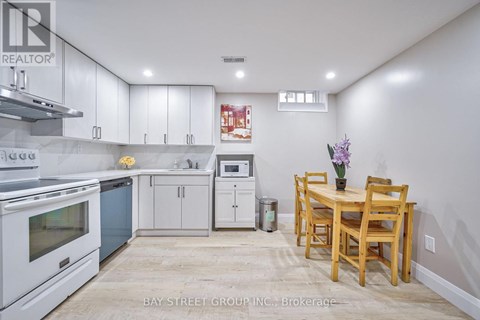 A kitchen with white cabinets and a wooden table.