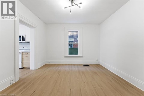 A room with wooden floors and a window showing a city view.