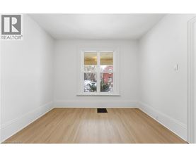 A room with a window showing a view of a street with buildings.