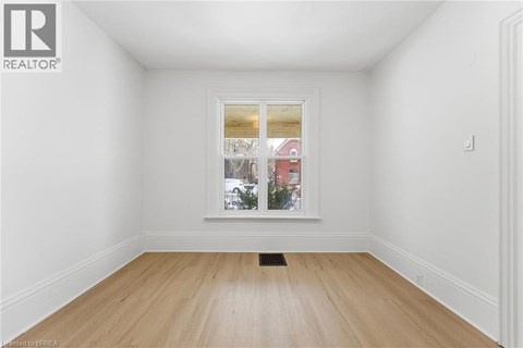 A room with a window showing a view of a street with buildings.